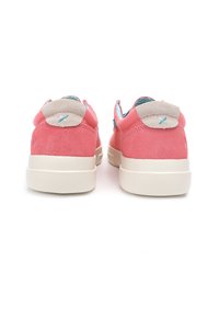 Pink suede sneakers with a beige suede heel tab, contrasting blue lining, and a flat white rubber sole. Back view highlighting design details.