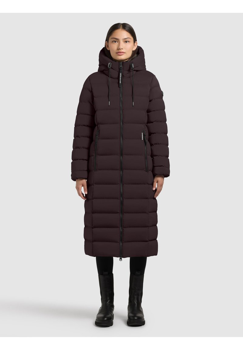 Long, dark purple puffer coat with a hood, featuring a front zipper and side pockets. Textured, quilted design enhances insulation. Black accents.