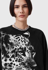 Felpa nera con una grande grafica di leopardo in monocromo, scollatura rotonda e polsini a costine con il testo "Allsaints" vicino al fondo.
