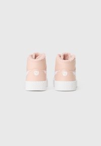 Une paire de baskets montantes roses avec des semelles blanches et une doublure en peluche, vue de l'arrière sur un fond blanc uni.