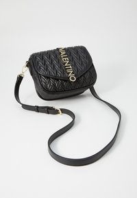 Borsa a tracolla in pelle intrecciata nera con chiusura a patta, accentuata da un logo dorato e tracolla regolabile. Presenta una superficie testurizzata.