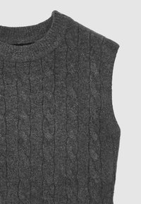 Pull sans manches en laine gris foncé à motif torsadé. Doté d'un col rond et d'un motif texturé sur tout le tissu.