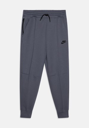 Ciemnoszare spodnie dresowe Nike z elastycznym pasem, czarnym sznurkiem, zasuwaną kieszenią boczną i ściągaczami przy kostkach.