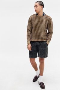 Pull en tricot brun à motifs avec un col côtelé ; short en velours côtelé noir ; chaussures en cuir brun ; chaussettes blanches mi-mollet ; coupe décontractée.