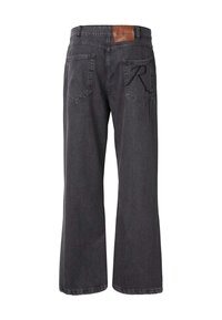 Mustat leveälahkeiset farkut, joissa on kulunut viimeistely, vyötäröllä nahkalaatta ja kaksi takataskua, joissa on kulmikkaat ompeleet.