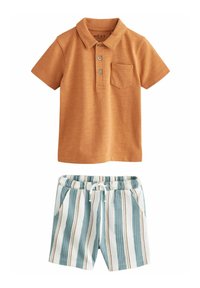 Poloshirt mit kurzen Ärmeln in rostrot, mit drei Knöpfen und einer Brusttasche, kombiniert mit gestreiften, hellblauen und weißen Shorts.