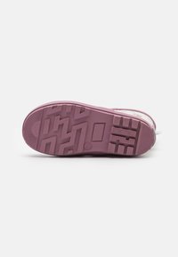 Semelle en caoutchouc violette de sneaker avec un motif de semelle en zigzag, texture lisse et deux petites indentations rectangulaires. Talon renforcé et détail de logo.