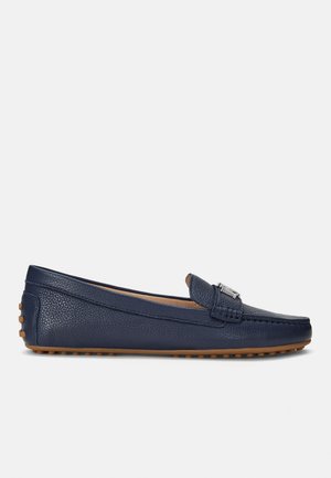 Mocassin en cuir bleu marine avec tige texturée, détail boucle argentée et semelle en caoutchouc camel avec crampons antidérapants.