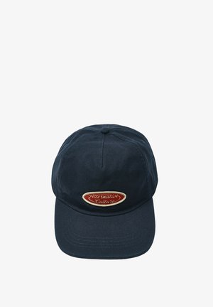 Casquette de baseball bleu foncé avec une visière incurvée et un patch ovale rouge à l'avant indiquant "Alternative Culture."