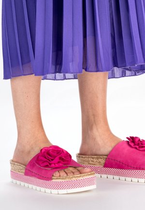 Rosa Wildledersandalen mit einem großen Blumendetail, Kork- und Zickzackmuster-Sohle, im Slip-On-Design und mit erhöhter Plattform.