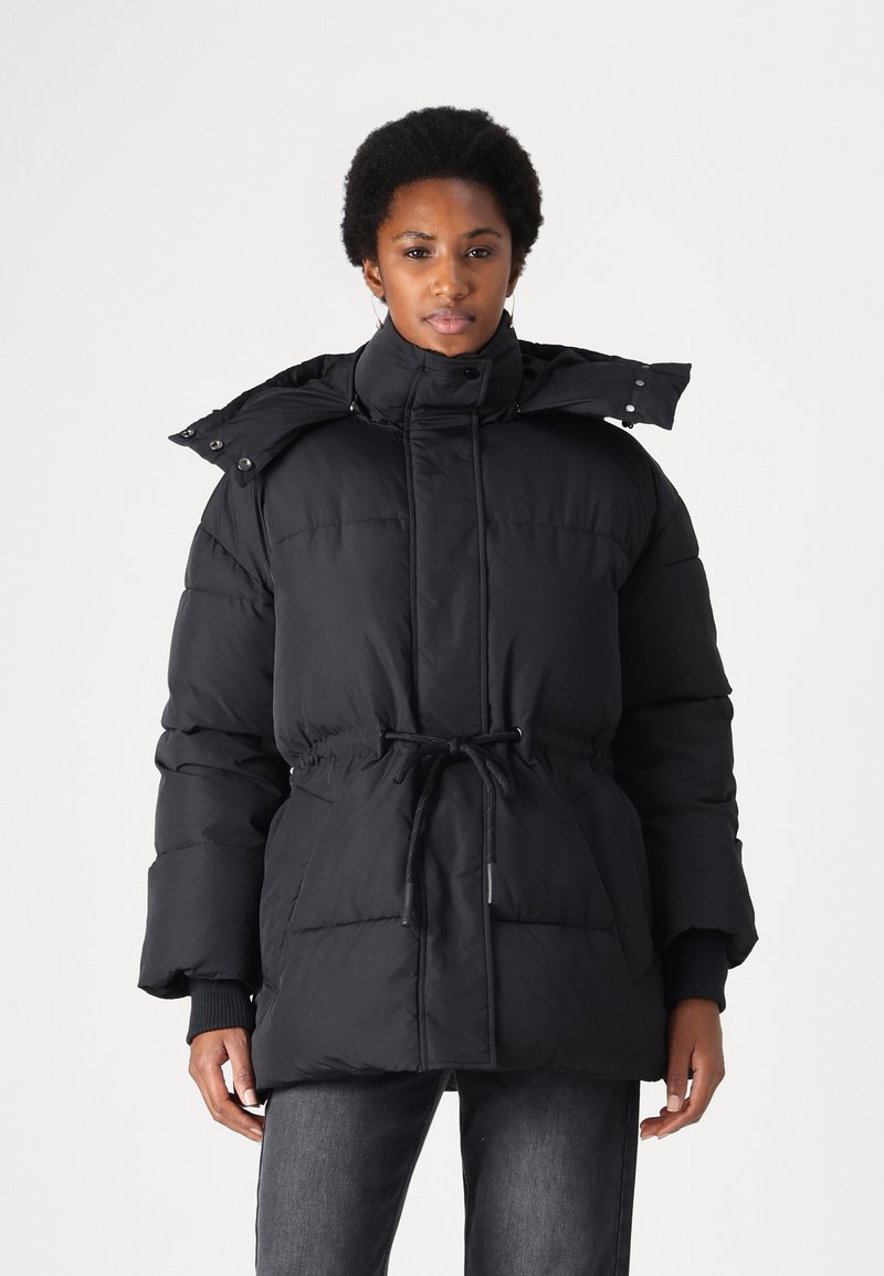 Black padded parka with a cinched waist, high collar, adjustable hood, and front snap buttons, featuring textured, insulated fabric.