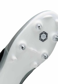 Semelle de chaussure de football avec une base en plastique blanc, des accents argentés, six crampons amovibles et un logo "ANTI CLOG TRACTION". Texture lisse.
