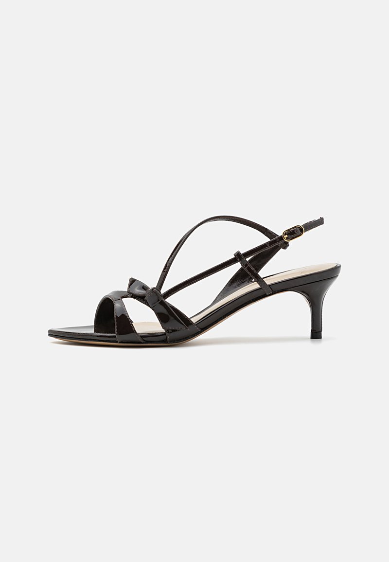Black patent leather heeled sandals with an open toe, cross-strap design, and a slender heel. Features an adjustable ankle strap.
