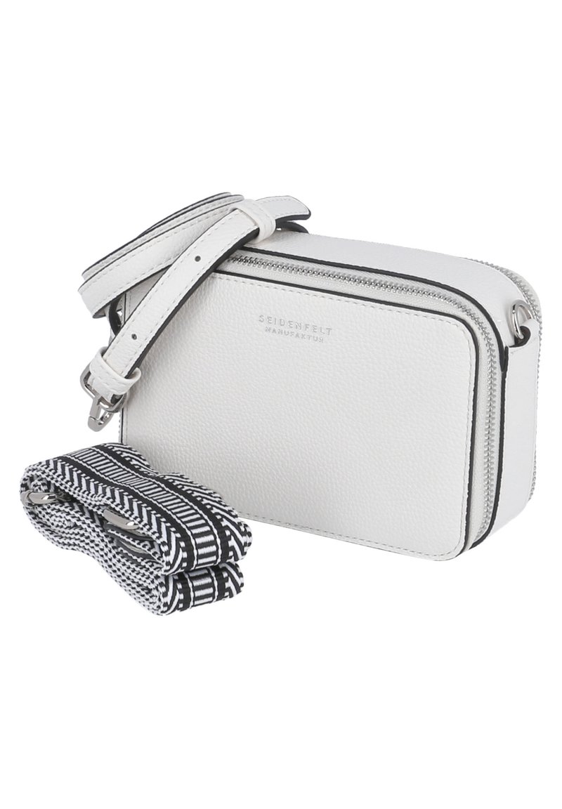 Vit läderaxelväska med dragkedja, med en avtagbar texturerad svart och vit mönstrad rem. Logotypen är präglad på framsidan.
