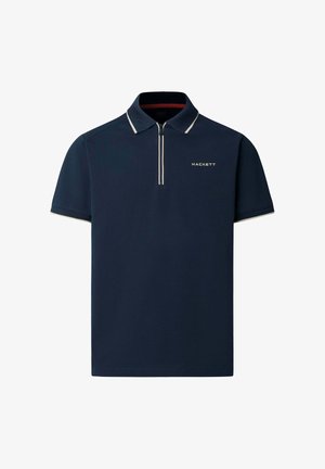 Marineblå polo-shirt med en lynlåslukning i kraven, korte ærmer og hvid kant. Har mærkenavnet "HACKETT" i diskrete hvide bogstaver på brystet.