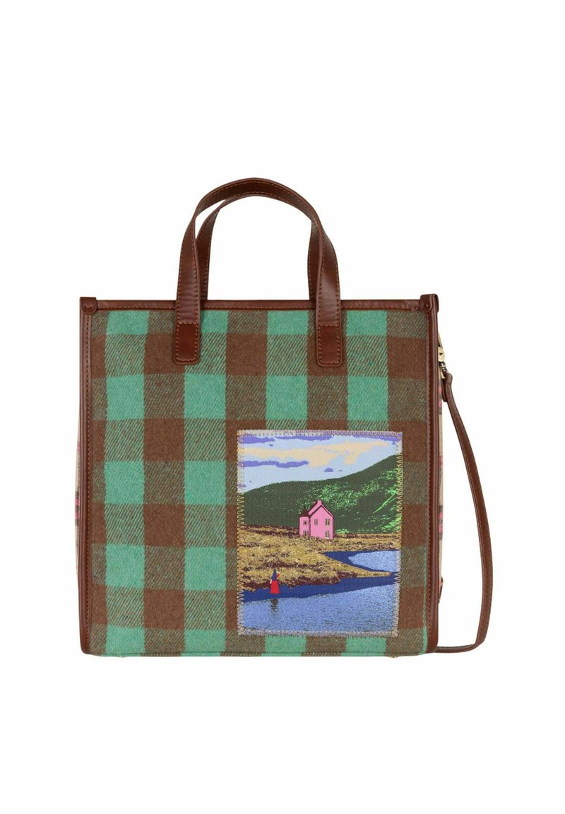 Sac en tartan marron et vert avec des poignées en cuir marron, arborant une scène colorée brodée d'une maison rose près de l'eau et des collines.