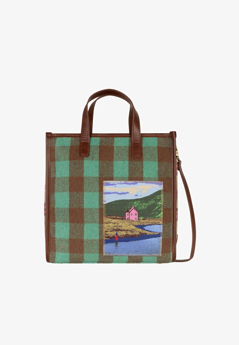 Sac en tartan marron et vert avec des poignées en cuir marron, arborant une scène colorée brodée d'une maison rose près de l'eau et des collines.