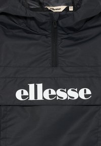 Juoda gobtuvinė striukė su priekiniais užtrauktukais ir dideliu baltu „ellesse“ logotipu per krūtinę, dydžio etiketė nurodo 10-11 metų.