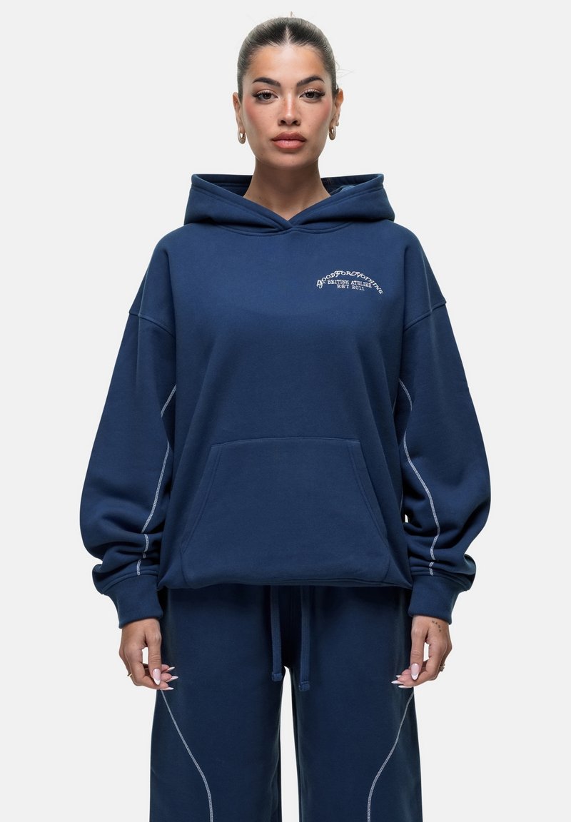 Felpa blu navy in tessuto morbido con tasca a marsupio anteriore, polsini a costine e cuciture a contrasto lungo le cuciture.
