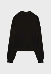 Črna krajša majica z ovratnikom, dolgimi rokavi in rebrastimi manšetami. Gladek oprijem s preprosto, minimalistično zasnovo.