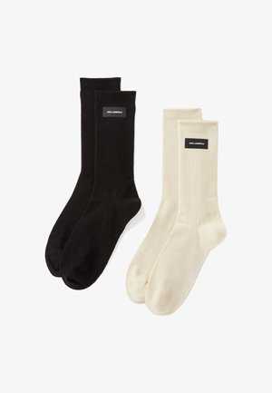 To sæt ribbede sokker: et i sort og et i creme. Hvert par har et logo tag på kanten. Blødt stof med en tætsiddende pasform.