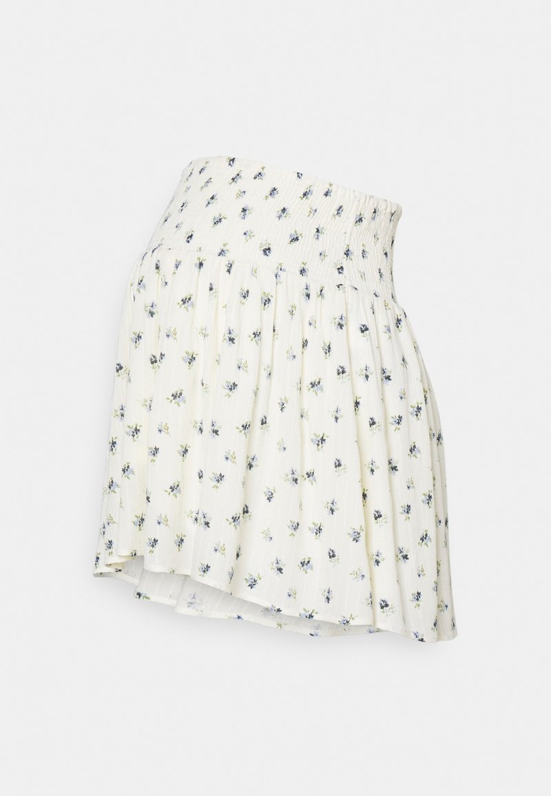 Falda corta de tela crema con estampado floral, que presenta una cintura fruncida y un diseño plisado, con acentos de flores azules y verdes.