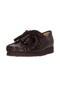 Donkerbruine leren moccasins met franjes en dikke crepezool, schuin geplaatst om de voor- en zijkantdetails te tonen.