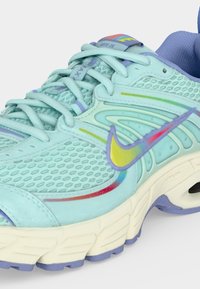 Ανοιχτό μπλε αθλητικό παπούτσι Nike για τρέξιμο με επάνω μέρος από δίχτυ, πολύχρωμο σήμα σε παστέλ τόνους, λιλά εσωτερική επένδυση και κρεμ σόλα με μοβ πέλματα.