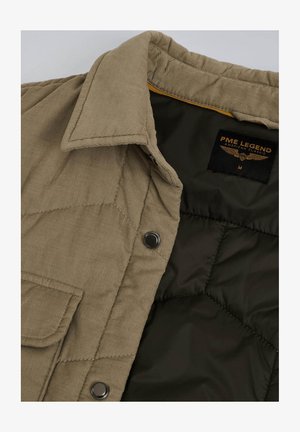 Giacca in velluto a coste beige con fodera trapuntata verde scuro, dotata di un'etichetta con il logo "PME Legend" e bottoni a pressione metallici sul davanti.
