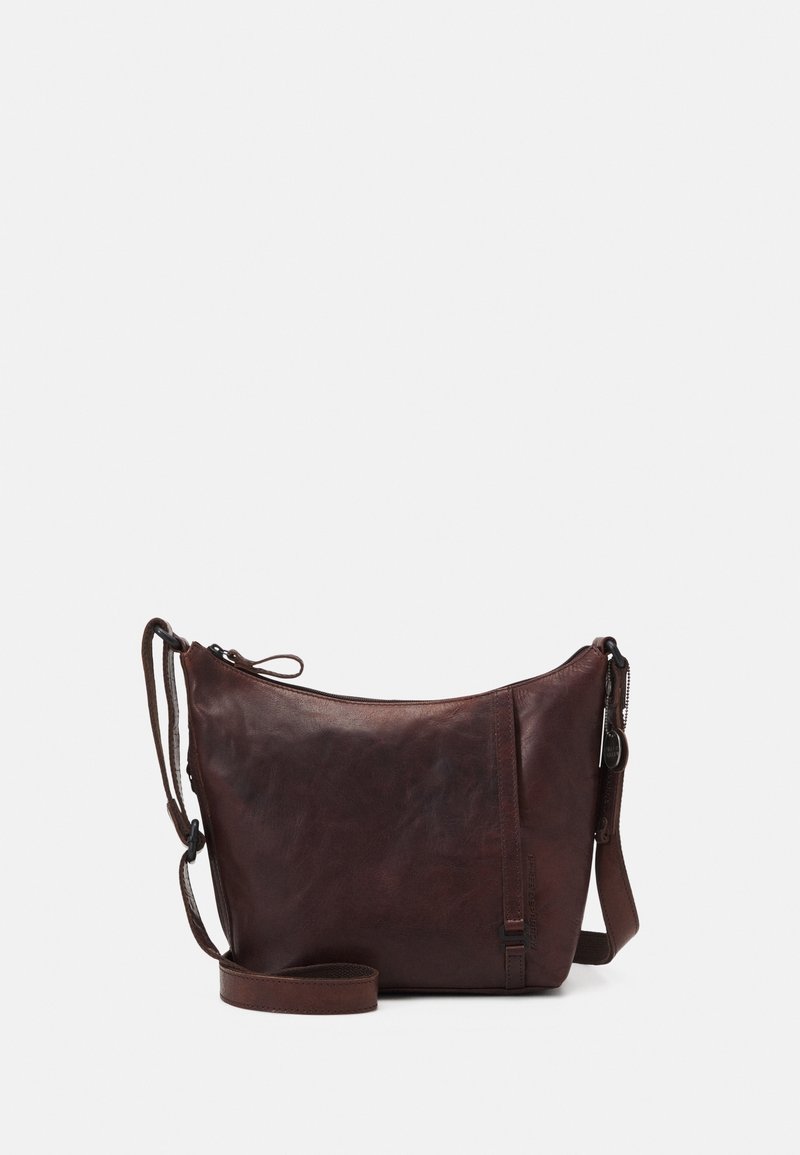 Sac en cuir marron en bandoulière avec une forme curvée, fermeture zippée, bandoulière ajustable et une texture subtile montrant des variations naturelles.