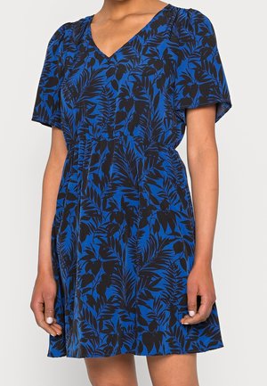 Blue dress with black leafy pattern, short sleeves, V-neck, and cinched waist worn by a person.