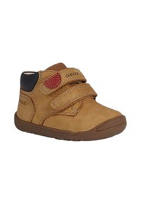 Stivali alla caviglia in pelle marrone con due fasce in Velcro, fodera in tessuto, suola in gomma e una patch rossa con il logo Geox.