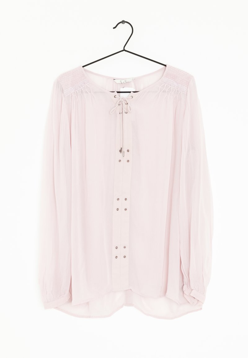 Blouse rose clair à manches longues avec un col à nouer, fermeture à boutons, poignets élastiques et détails texturés aux épaules. Réalisée dans un tissu lisse et aérien.