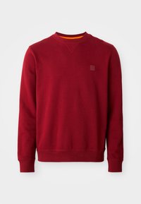 Sweat-shirt rouge en mélange de coton, doté d'un col rond, de poignets côtelés et d'un petit patch logo sur la poitrine. Texture lisse.