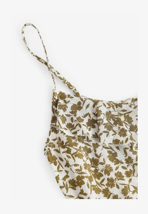 Bloemrijke spaghettitop met dunne verstelbare bandjes, voorzien van een gerimpelde halslijn. De stof is licht en heeft een groen bloemendessin op een crèmekleurige achtergrond.