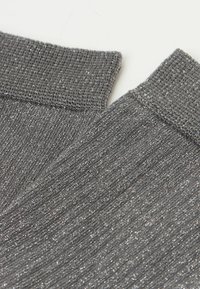 Grå, ribbade benvärmare gjorda av ett skimrande, texturerat stickat material med en mjuk, elastisk överkant, perfekt för extra värme.