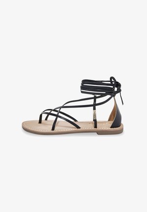 Schwarze Leder-Gladiatoren-Sandale mit mehreren Riemen, flacher Sohle und gebundenem Knöchel-Design. Beigefarbene Fußbett mit Steppdetails.
