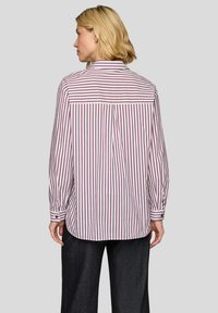 Long-sleeve shirt with vertical white and burgundy stripes, back yoke detail, and buttoned cuffs, made from a lightweight fabric.