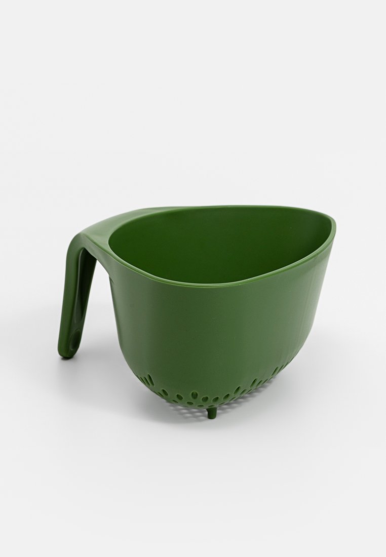 Colador de plástico verde con asa y patas pequeñas, diseñado para escurrir líquidos de alimentos como pasta o verduras.