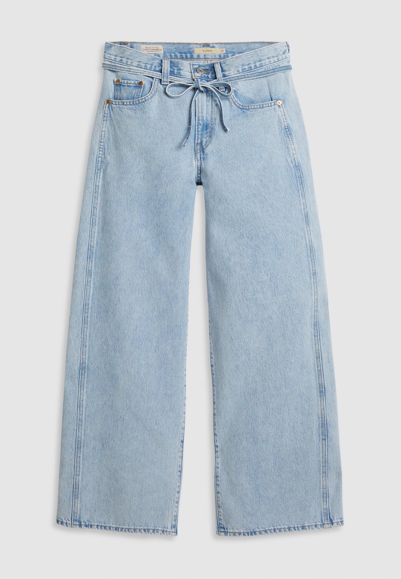 Jeans larges bleu clair en denim, dotés d'une taille à cordon, de deux poches avant et de détails de couture visibles le long des coutures.