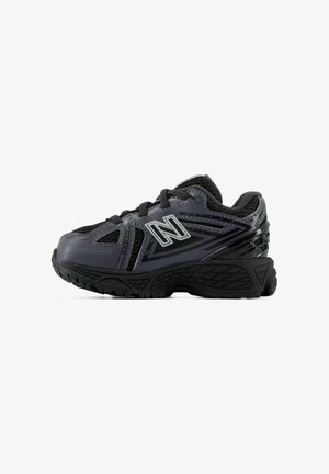 Sort og mørkegrå atletikskos med mesh-stof, tyk sål, snørebånd og New Balance-logo på siden.