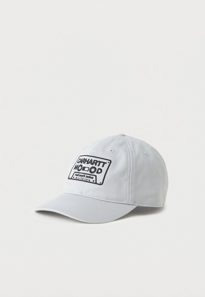Gorra de béisbol gris claro con un parche bordado negro que muestra una cinta de casete y el texto "Carhartt Mood" en el frente.