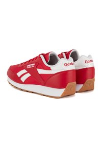 Sneakers in pelle rossa con dettagli bianchi, colletto imbottito e suola in gomma. Presentano una chiusura frontale con lacci e un design distintivo con striscia laterale.