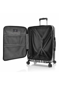 Schwarze und weiße gestreifte Hartschalenkoffer mit Innenfächern, Netztaschen und einem ausziehbaren Griff. Vier Räder für Mobilität.
