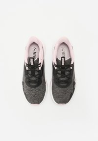 Mustat ja harmaat urheilukengät, joissa on teksturoitu verkko-osa ylhäällä, vaaleanpunaiset yksityiskohdat ja mustat nauhat. PUMA-logo kielellä ja sivulla.