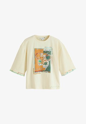 Kremfarvet T-shirt med korte ærmer med et farverigt vasegrafik foran og dekorative zigzag-syninger nær ærmerne og nederste kant.