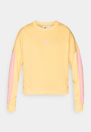 Κίτρινη φούτερ μπλούζα με ροζ τρεις ρίγες στα μανίκια. Διαθέτει στρογγυλή λαιμόκοψη και ριμπ μανσέτες. Φτιαγμένη από μαλακό ύφασμα από βαμβάκι και πολυεστέρα.