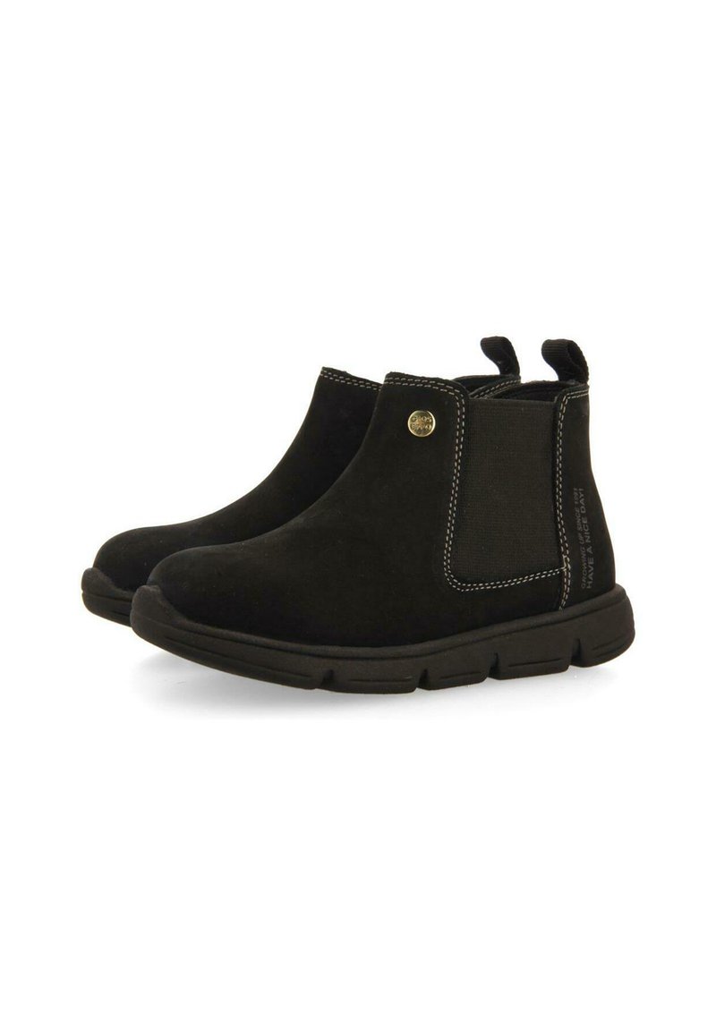 Botas de tobillo de ante negro con paneles elásticos laterales, costuras en blanco contrastante y lengüetas para facilitar el calzado. Suela de goma para mayor tracción.