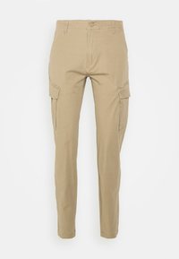 Pantalon cargo beige slim fit avec bouton à l'avant, fermeture éclair, passants de ceinture et poches à rabat sur les deux cuisses, sur un fond uni.
