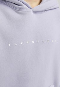 Felpa lavender in morbido tessuto con tasca frontale e testo bianco "JACK & JONES" sul petto in carattere sans-serif.
